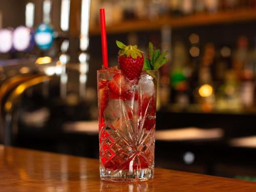 a drink with strawberries and ice on a table at Novotel London Wembley in London