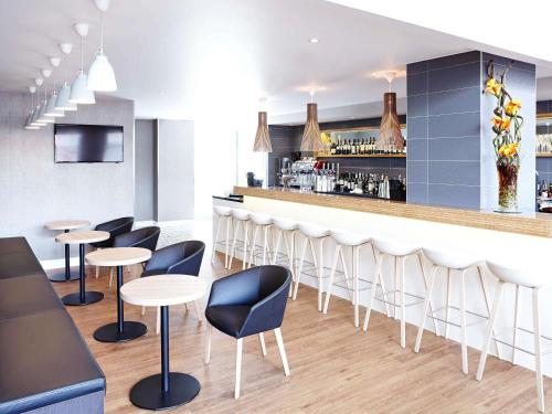 a bar in a restaurant with chairs and tables at Novotel London Wembley in London