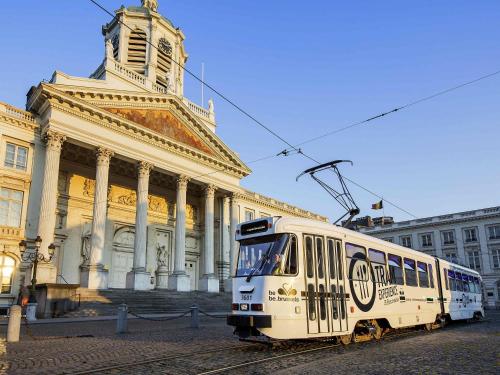 a white tram in front of a building at ibis Styles Hotel Brussels Centre Stéphanie in Brussels