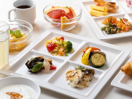 uma mesa com pratos brancos de comida em ibis Styles Kyoto Station em Quioto