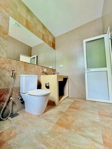 a bathroom with a toilet and a mirror at Alex's Place in Ja-Ela