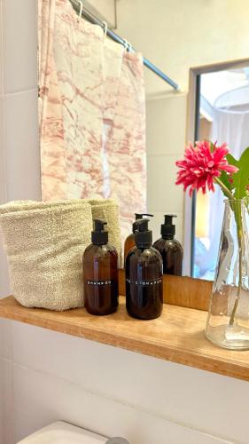 a bathroom shelf with three bottles of soap at Las Luciernagas Posada de Mar in La Pedrera