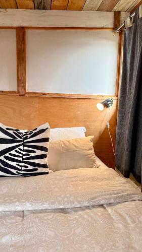a bed with a headboard and a lamp next to it at Las Luciernagas Posada de Mar in La Pedrera
