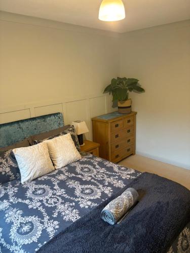 a bedroom with a bed and a plant on a dresser at The Bungalow at Montrave in Fife