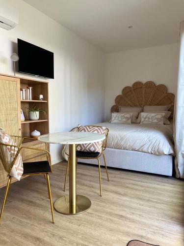 a bedroom with a bed and a table and chairs at La suite de cœurs avec jacuzzi in Gradignan