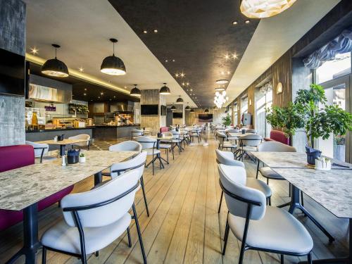 a restaurant with rows of tables and chairs at Mercure Riga Centre in Rīga