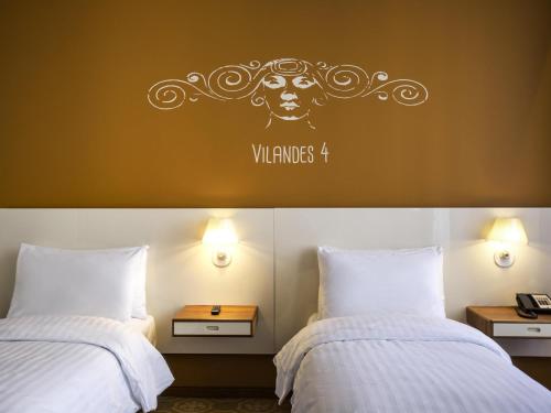 a bedroom with two beds and a sign that reads wrinkles four at Mercure Riga Centre in Rīga