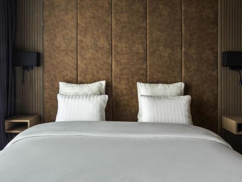 a bedroom with a large bed with two pillows at Mercure Riga Centre in Rīga
