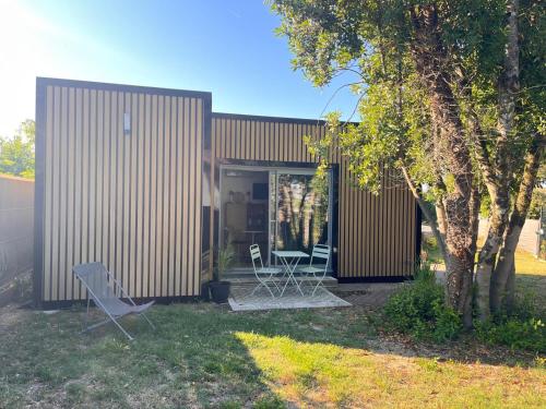 a house with two chairs and a table in a yard at La suite de cœurs avec jacuzzi in Gradignan