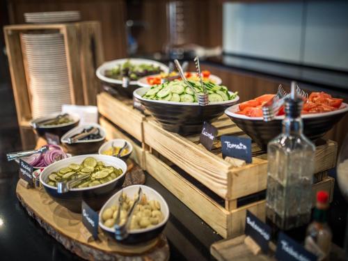 a buffet with bowls of different types of food at Mercure Riga Centre in Rīga