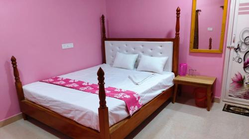 - une chambre avec un lit dans une chambre rose dans l'établissement Hotel ruposhi bangla, à Purbbadulki