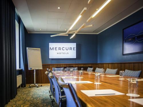 a conference room with a long table and chairs at Mercure Riga Centre in Rīga
