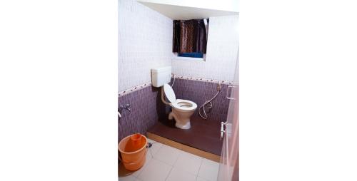 La salle de bains est pourvue de toilettes et d'une fenêtre. dans l'établissement KP Holidays తెలుగు Cottage, à Ooty