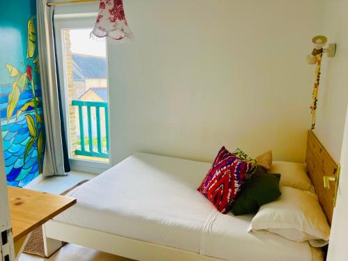 a white couch in a room with a window at Coco bay 2 in Saint-Benoît-des-Ondes