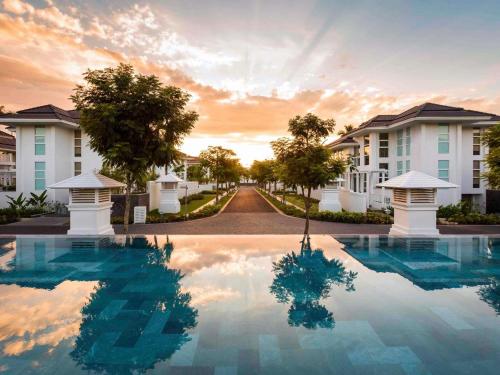 a villa with a swimming pool at sunset at Premier Village Danang Resort Managed By Accor in Da Nang