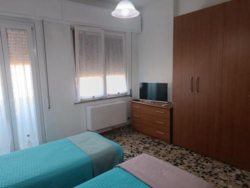 a small bedroom with two beds and a television at La Vista Storica in Piombino