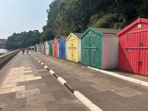 a row of colorful beach huts on a sidewalk at Charming 2 Storey Holiday Villa in Dawlish Warren in Dawlish Warren
