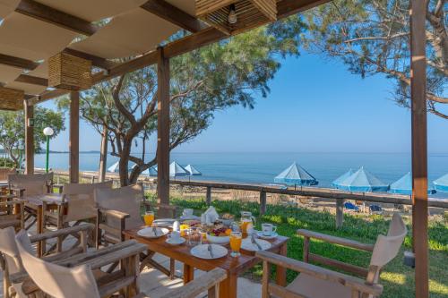 a restaurant with a table and chairs and the ocean at Harmony Hotel in Kourouta