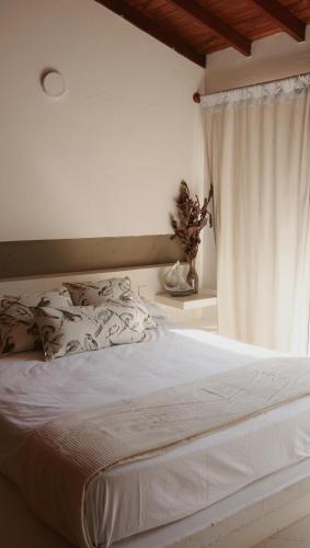 a bedroom with a white bed with a window at Alquiler casa en la playa, Tolu in Tolú