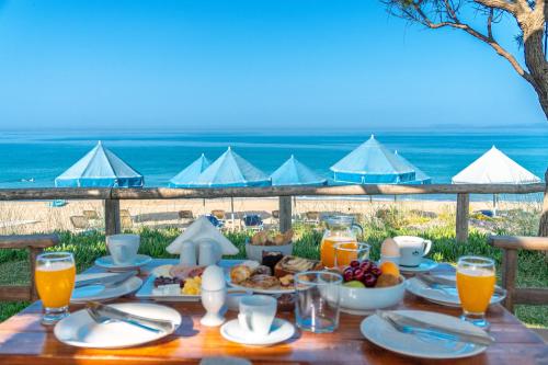 a table with food and the ocean in the background at Harmony Hotel in Kourouta