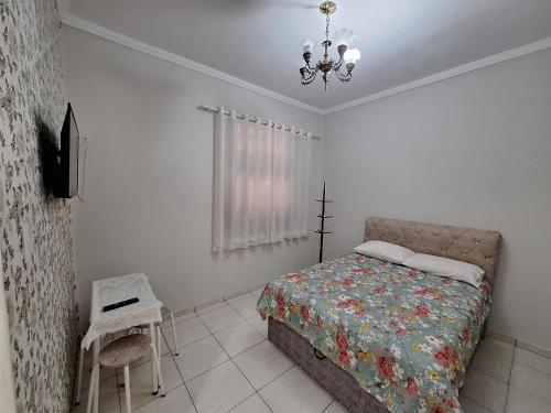 a bedroom with a bed and a chandelier at Loft in the Center of Serra Negra in Serra Negra