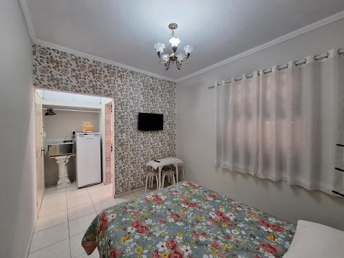 a bedroom with a bed and a refrigerator in it at Loft in the Center of Serra Negra in Serra Negra