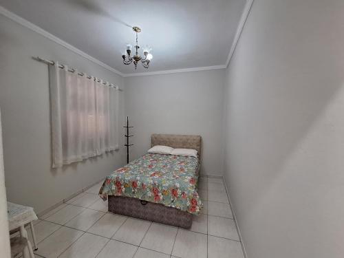 a bedroom with a bed and a chandelier at Loft in the Center of Serra Negra in Serra Negra