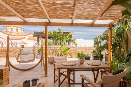 een terras met een houten tafel en stoelen bij Baulus Yard Luxury I in Heraklion