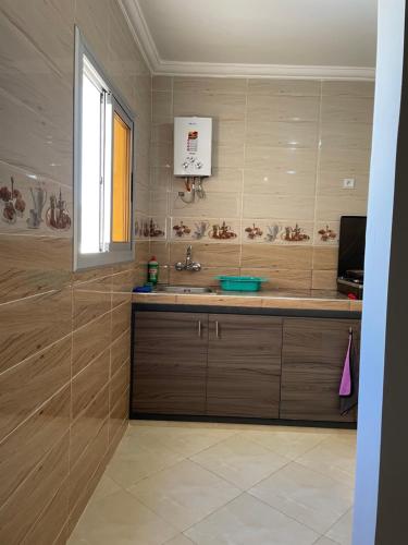 a bathroom with a sink and a television in it at Appartement Neuf Plage Mdiq in M'diq