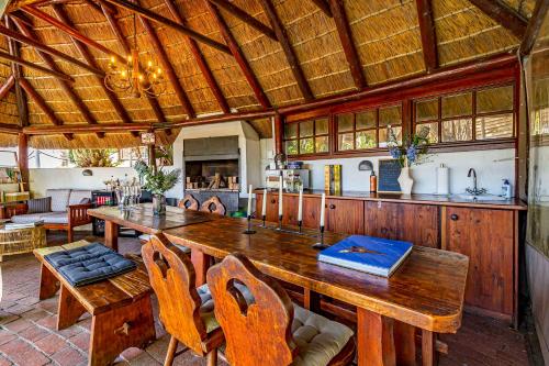 una grande sala da pranzo con un grande tavolo in legno di Villa Helderberg a Somerset West