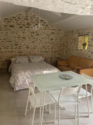 a bedroom with a bed and a table and chairs at Le clos de Tilio in Saint-Jean-de-Thouars