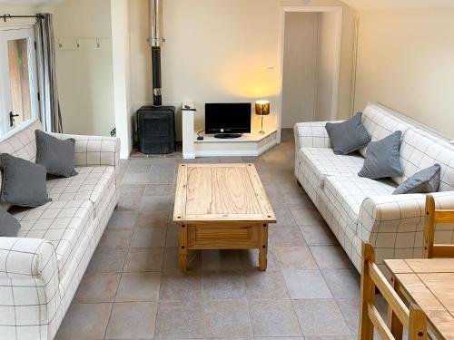 a living room with two couches and a coffee table at Little Barn - Hw7615 in Bettws-yn-Rhôs