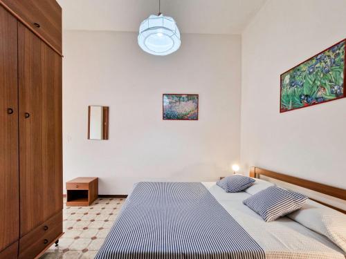 a bedroom with a bed and a pendant light at Condominio Carina Sud in Bibione