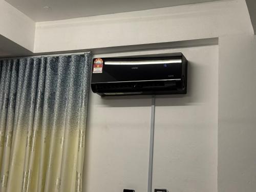 a air conditioner on a wall next to a curtain at Driff studio B Wakaf Che Yeh in Kota Bharu
