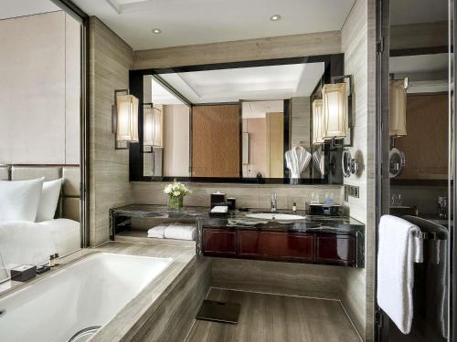 a bathroom with a tub and a sink at Pullman Weifang in Weifang