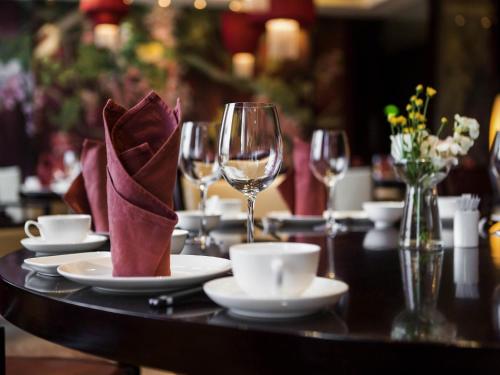a table with plates and wine glasses on it at Pullman Weifang in Weifang