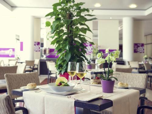 a table with two glasses of white wine at Mercure Genova San Biagio in Genova