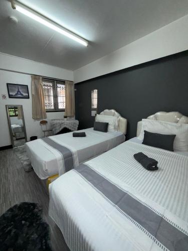 a hotel room with two beds with white sheets at Ree House- Sukhumvit 23 in Bangkok