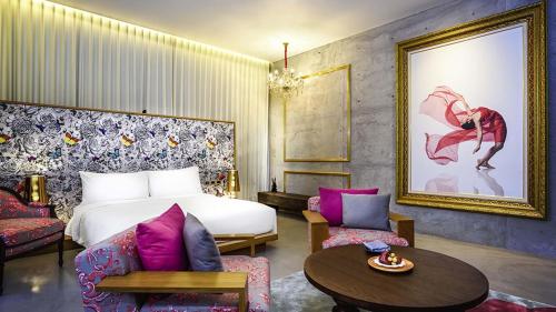 a hotel room with a bed and a table and chairs at SO/ Sofitel Hua Hin in Cha Am