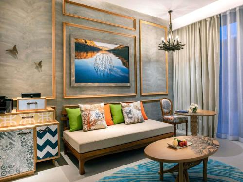 a living room with a couch and a table at SO/ Sofitel Hua Hin in Cha Am