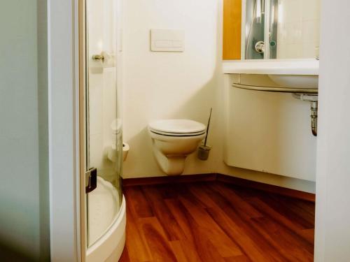 a small bathroom with a toilet and a sink at Ibis Sofia Airport Hotel in Sofia