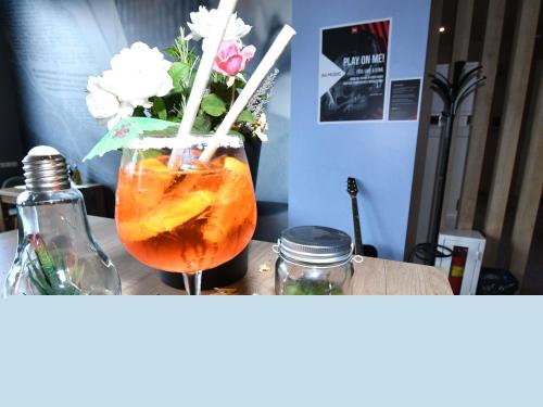 a vase of flowers and a drink on a table at Ibis Sofia Airport Hotel in Sofia