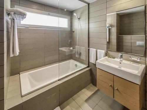 a bathroom with a tub and a sink and a shower at Mercure Quemado Al-Hoceima Resort in Al Hoceïma