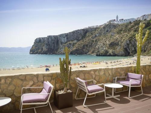 a patio with chairs and tables and a beach at Mercure Quemado Al-Hoceima Resort in Al Hoceïma
