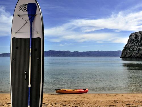 a surfboard sitting on the beach next to a kayak at Mercure Quemado Al-Hoceima Resort in Al Hoceïma