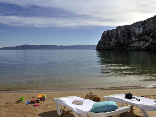 a beach with two white tables and the water at Mercure Quemado Al-Hoceima Resort in Al Hoceïma