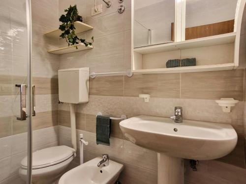 a small bathroom with a sink and a toilet at Condominio Carina Sud in Bibione