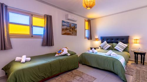 a bedroom with two beds with stuffed animals on them at Riad Ghazal in Essaouira
