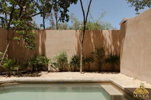 a swimming pool in front of a fence at Peregrina Tulum Lux Aparthotel in Tulum