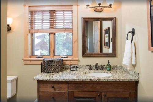 a bathroom with a sink and a mirror and a window at Luxury Home with Stunning 4 Peak Views in Tetonia